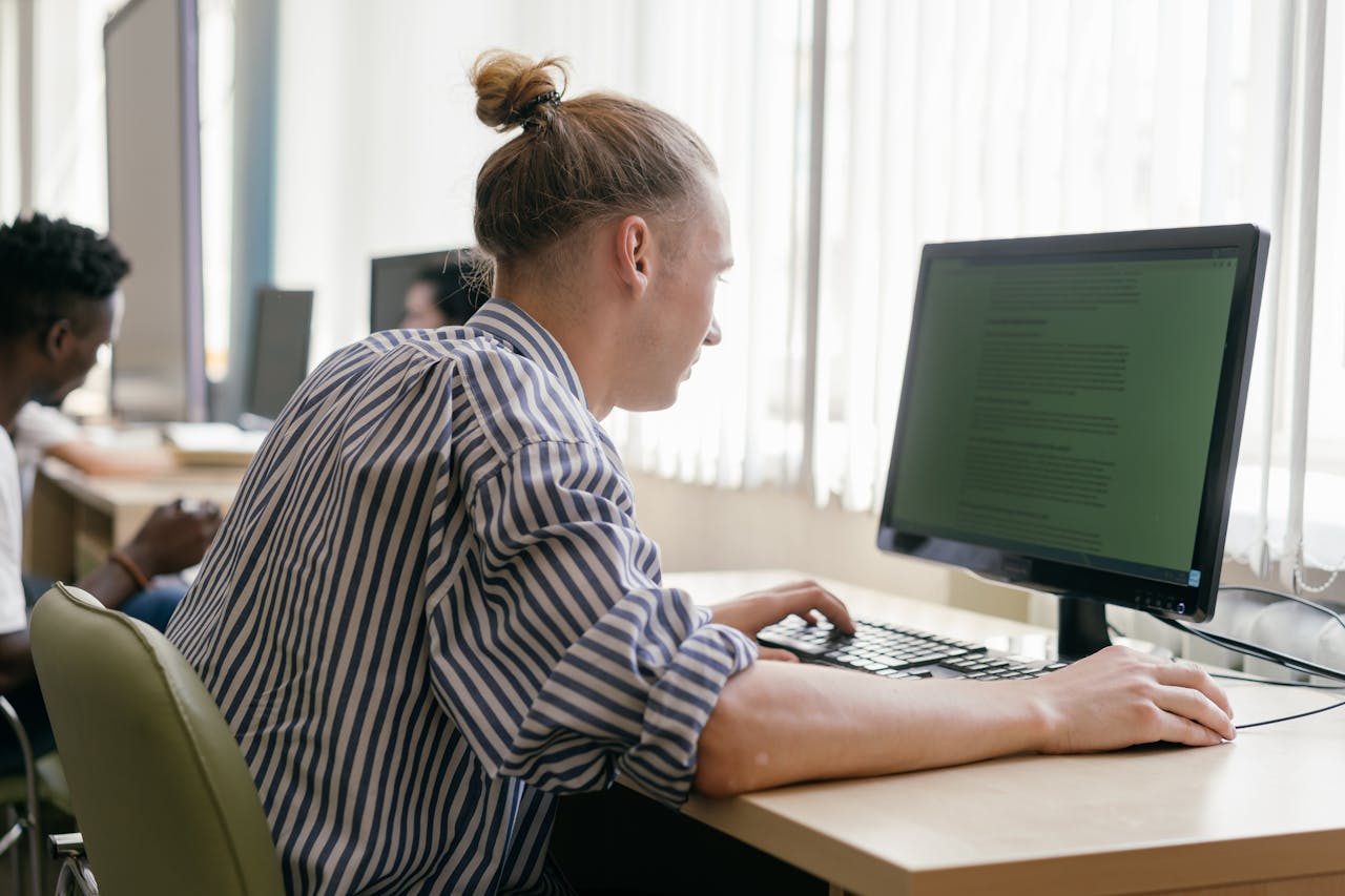 Focused student working on a computer in a bright, modern study space.